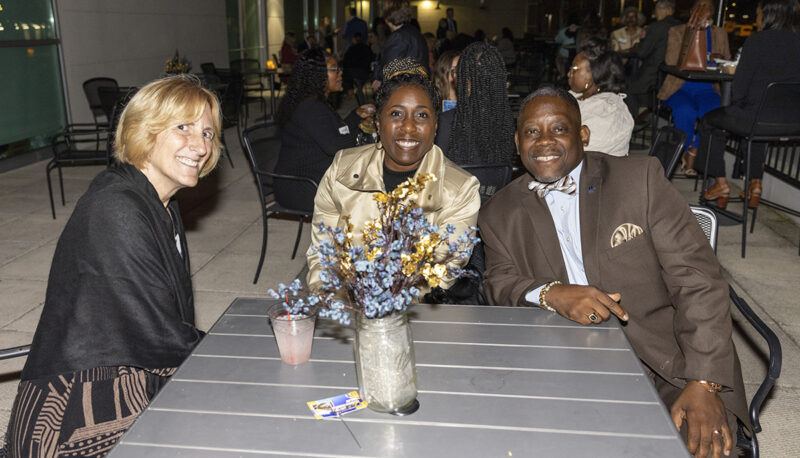 Interim Dean Donna Fry sitting with two alumni