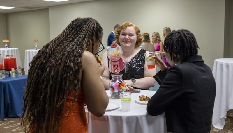 students in formal dress speaking at a table