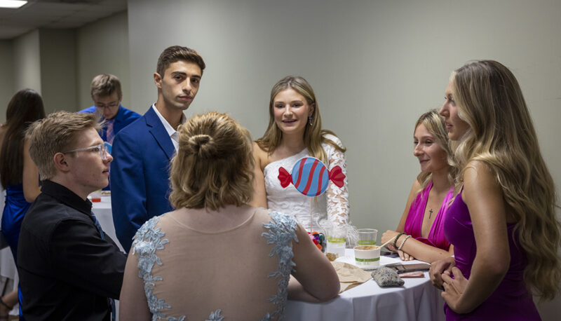 students in formal dress speaking at a table