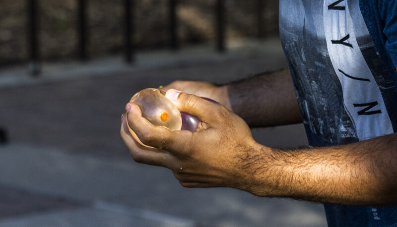 A close up of a student holding water balloons