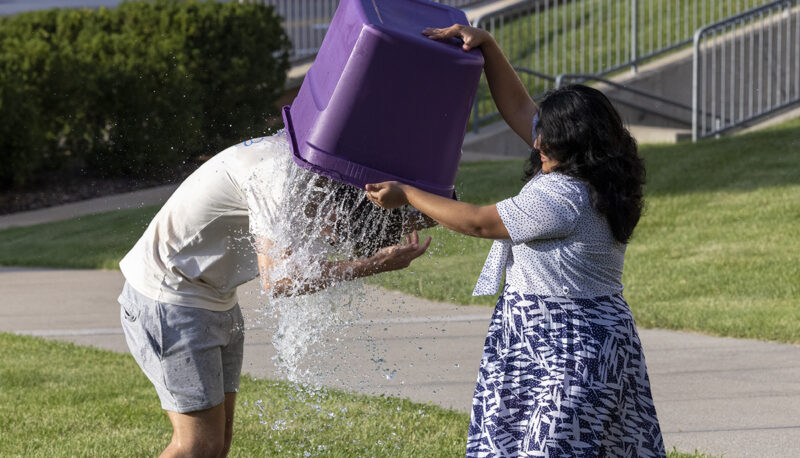 A student dumping a tub of water on another