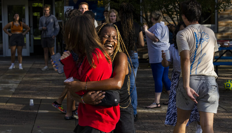 students hugging each other at a water fight