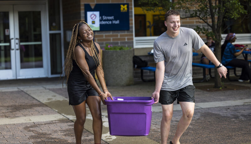 Group of students carrying a tub of water balloons