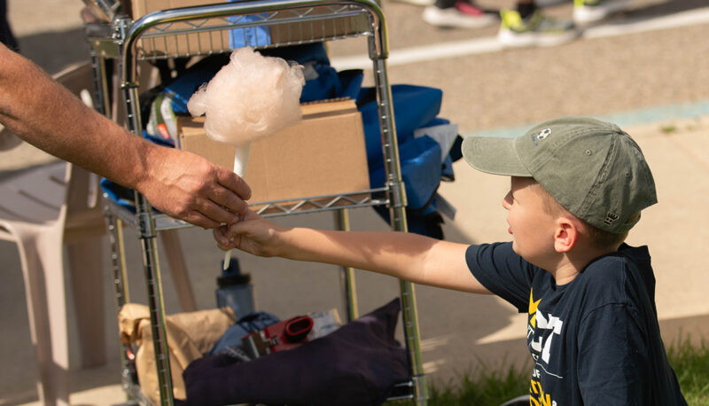 A young child being handed a cotton candy