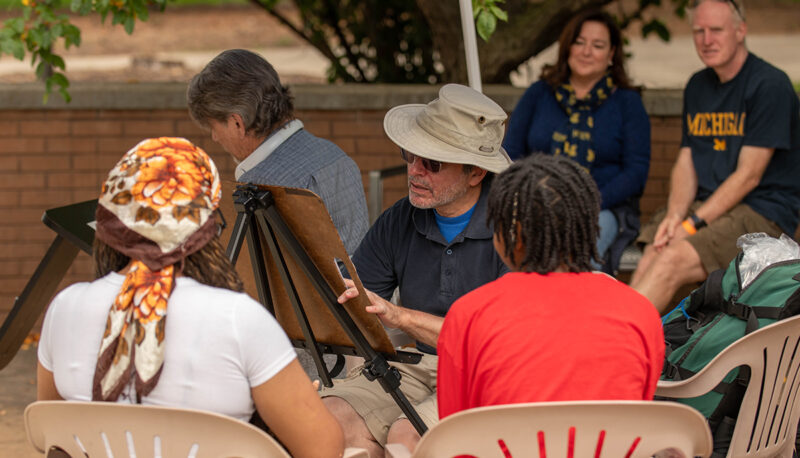 Students sitting for a caricature portrait