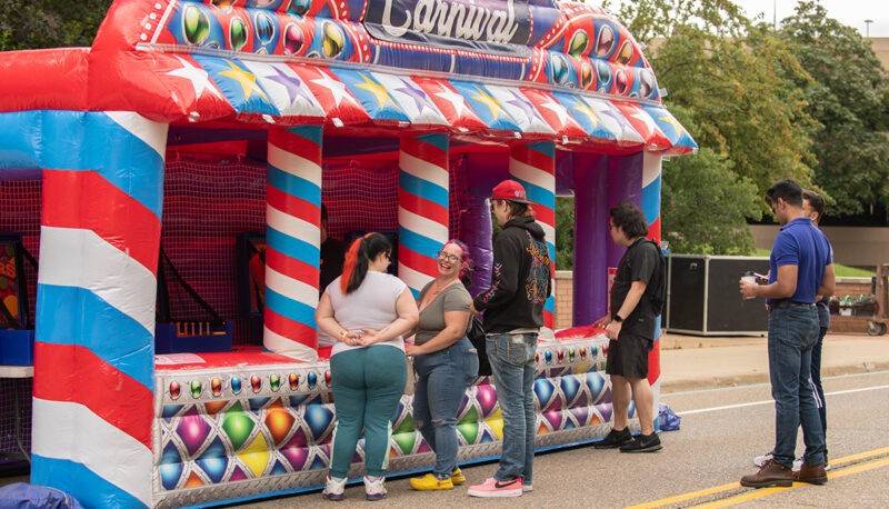 Students standing in line front of a carnival game