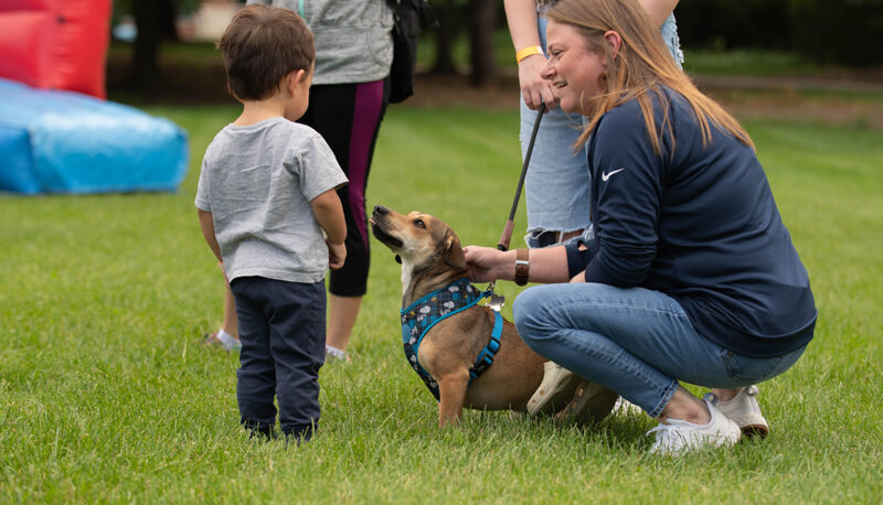 A young child standing with a puppy