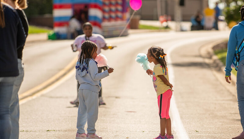 Tow young kids standing with cotton candy