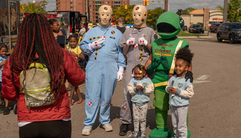 Kids posing with crash test dummy mascots