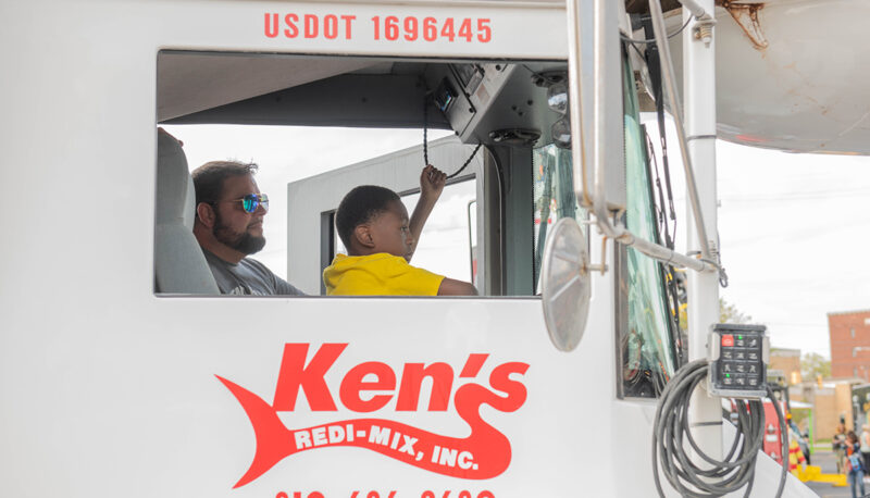 A kid honking the horn in a big truck