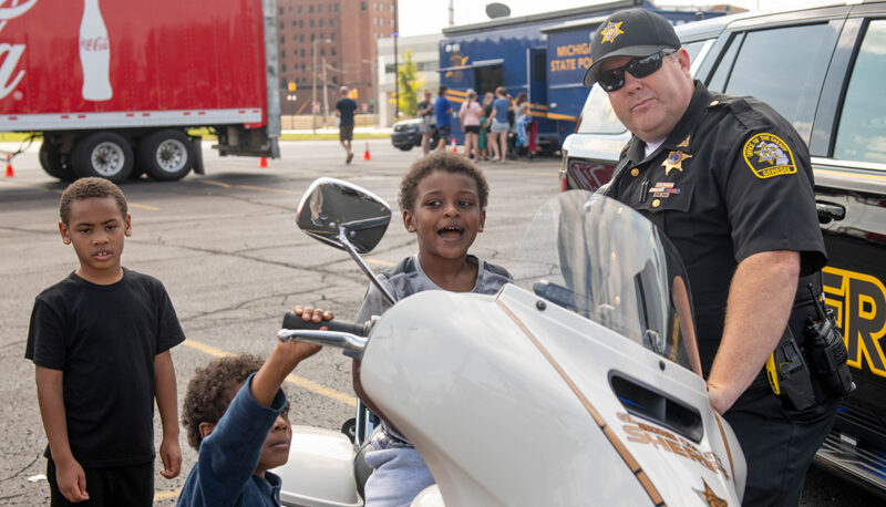 Motorcycle police with kids checking out the motorcycle