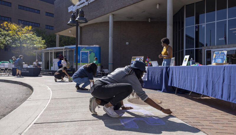 Students using sidewalk chalk at Eco Extravaganza