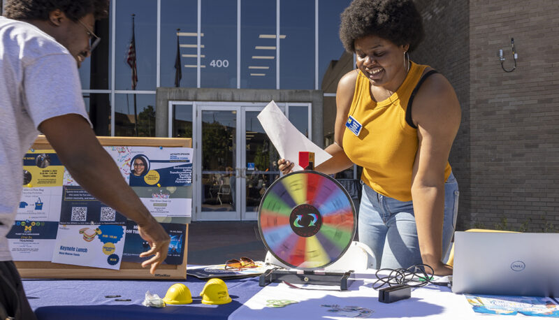 A student spinning a prize wheel at Eco Extravaganza