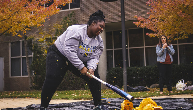 A student smashing a pumpkin