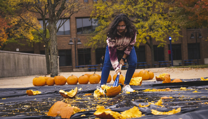 A student smashing a pumpkin