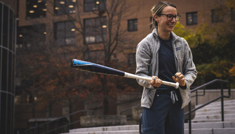 A student holding a baseball bat about to smash a pumpkin