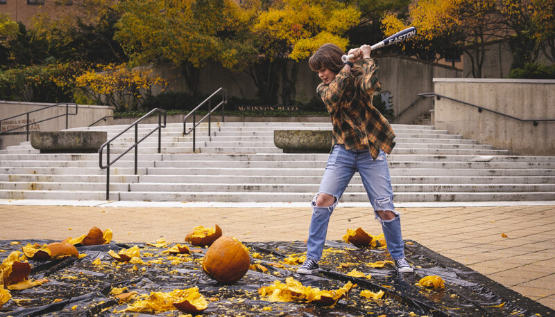 A student smashing a pumpkin