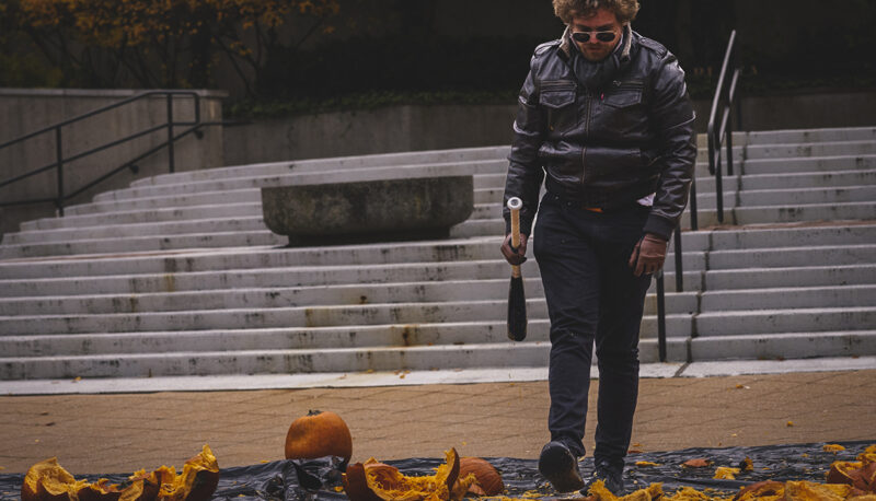 A student smashing a pumpkin