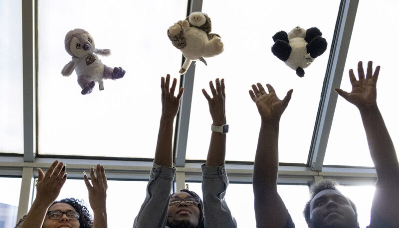 A close up of students throwing their plushies in the air