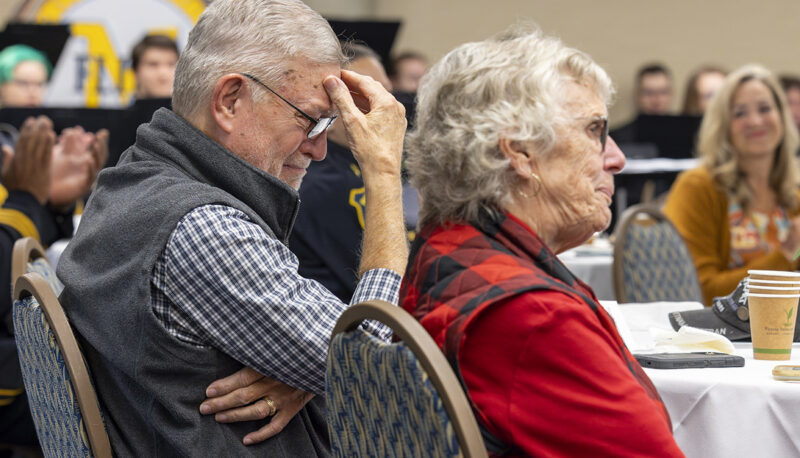 An attendee of the Veterans Day reception puts his head in his hand.