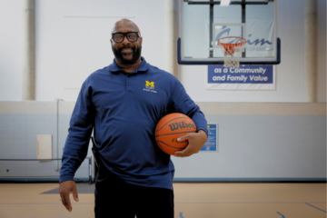 Ervin Leavy Jr. holds a basketball and stands for a portrait in the UM-Flint Rec Center.