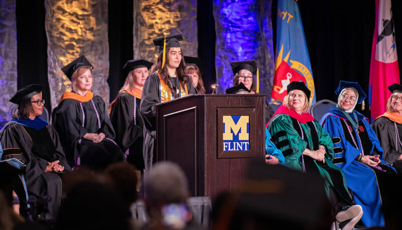 A student speaking at the commencement podium