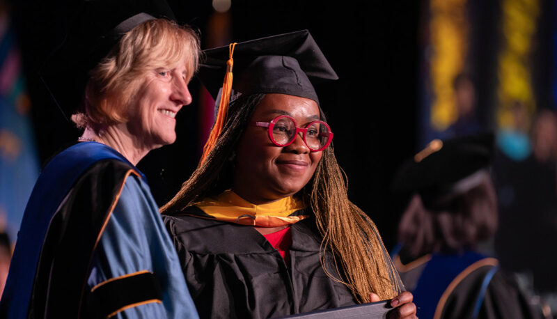 A student posing with Donna Fry