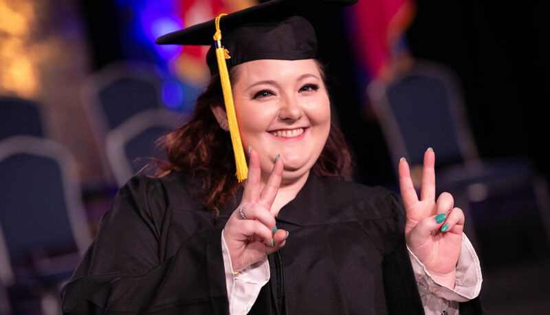 A student throwing a piece sign