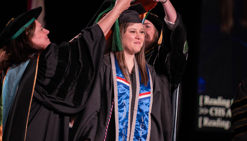 A student receiving graduation regalia