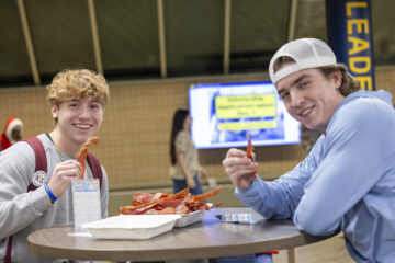 Students posing with a plate of bacon