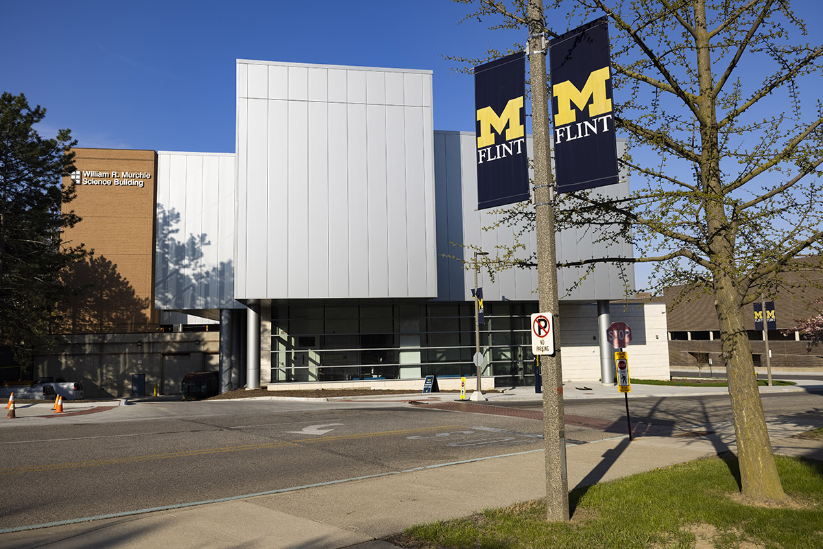 Exterior of UM-Flint's Murchie Science Building with UM-Flint banner on lightpole