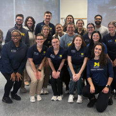 A group of occupational therapy and physical therapy students pose for a group photo during a lab for ALS caregivers