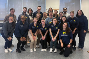 A group of occupational therapy and physical therapy students pose for a group photo during a lab for ALS caregivers