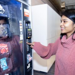 A UM-Flint student accesses the new health and wellness vending machine installed in the second floor of the UCEN.