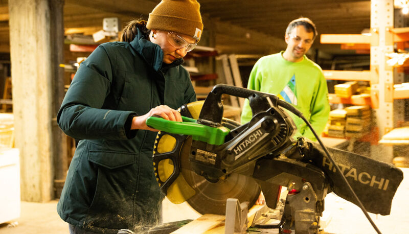 A UM-Flint student operating a circular saw.