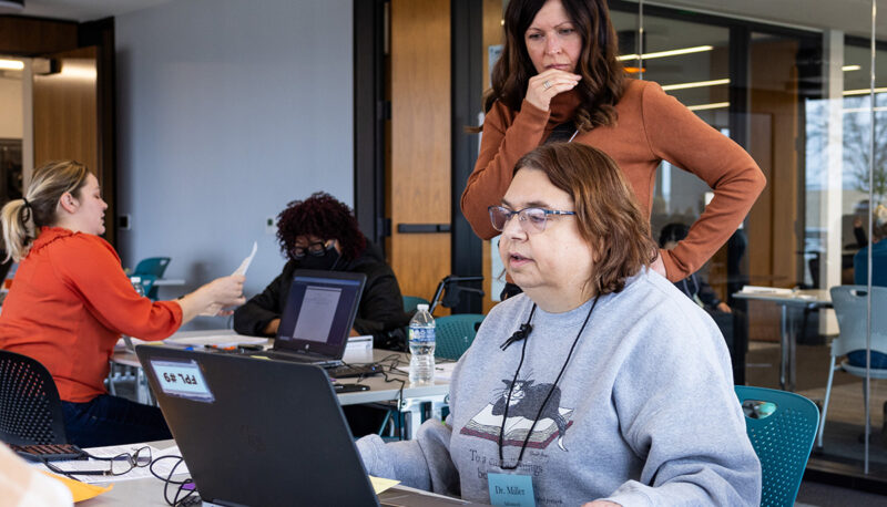 Cathleen Miller and another woman looking at a laptop