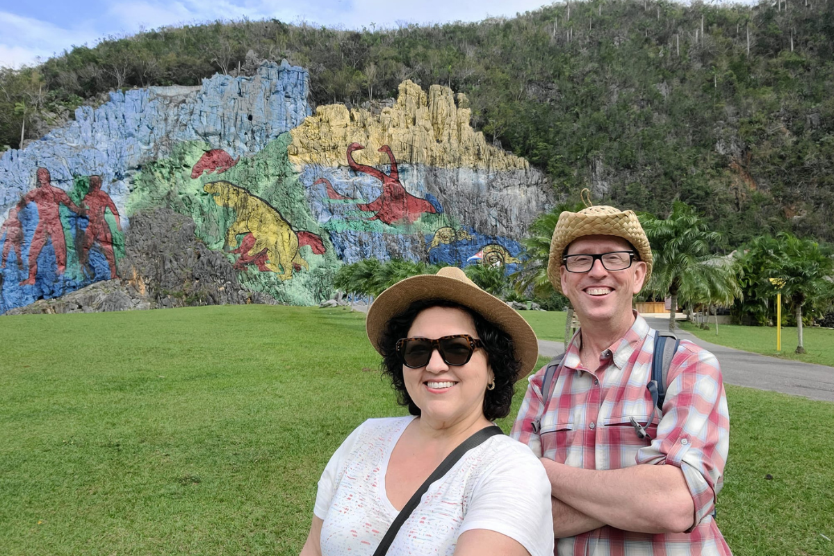 UM-Flint faculty members Stephanie Vidaillet Gelderloos (front) and Thomas Henthorn (rear) posing in front of a mural