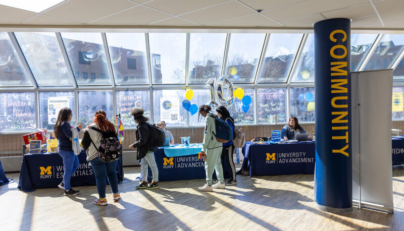 A group of students looking at the Giving Blueday Tables in the University Center