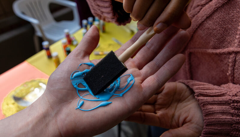 A closeup of paint being applied to a hand