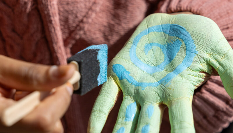 A closeup of paint being applied to a hand