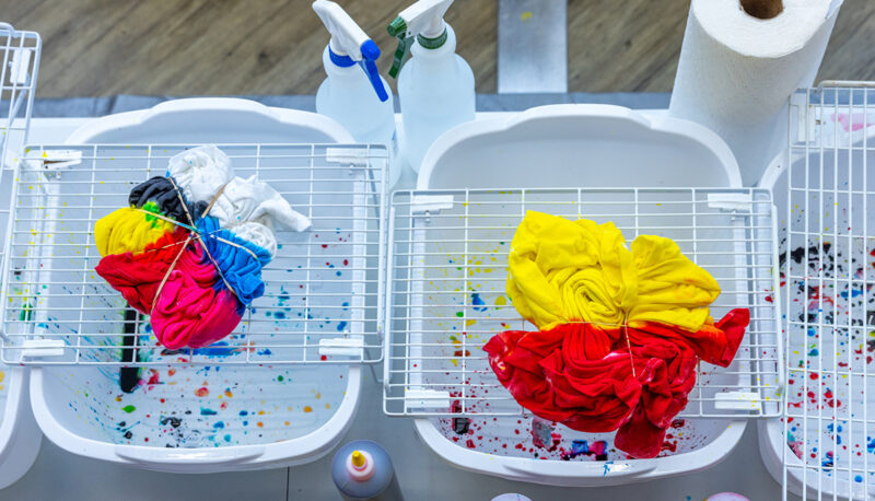 Tie dye shirts drying on a rack