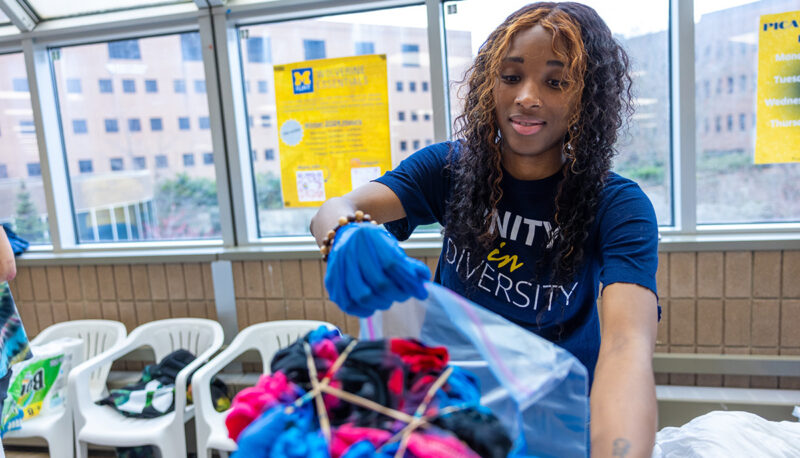 A student with a bag of dyed t shirts