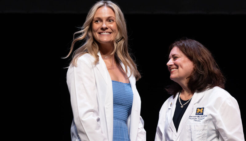 A female student receiving her white coat.