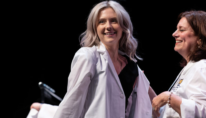 A female student receiving her white coat.