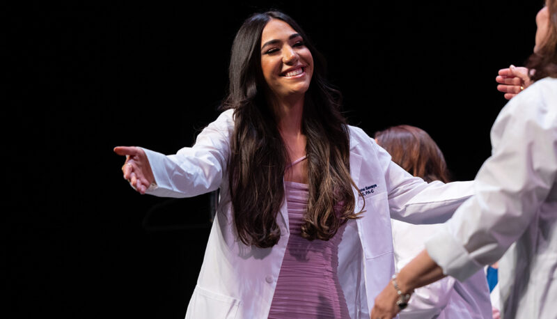 A female student receiving her white coat.