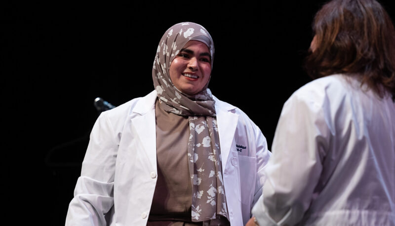 A female student receiving her white coat.