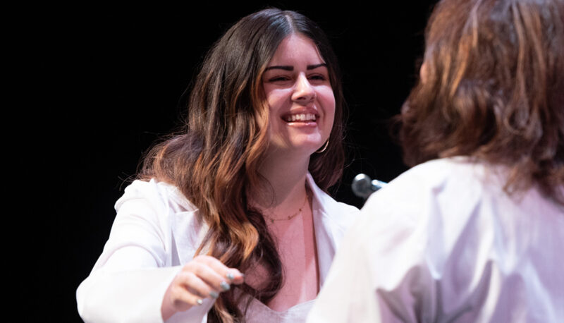 A female student receiving her white coat.