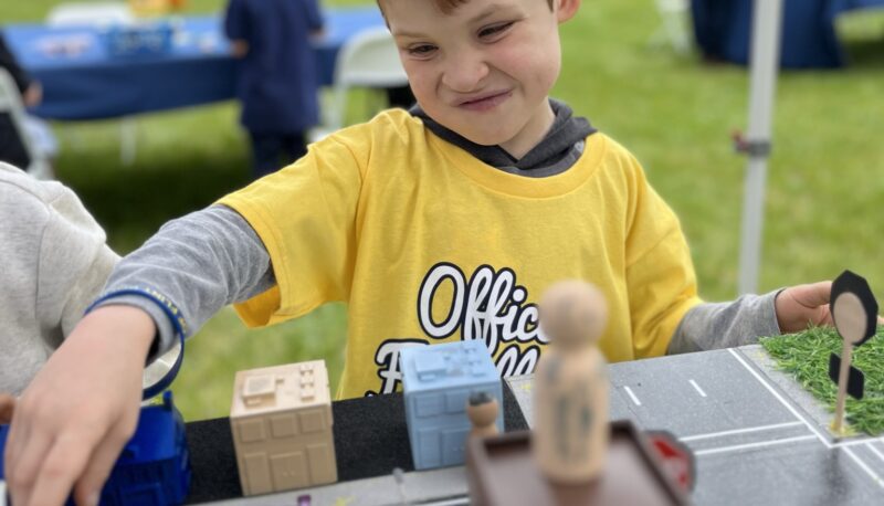 A young officer friendly day attendee playing with hotwheels