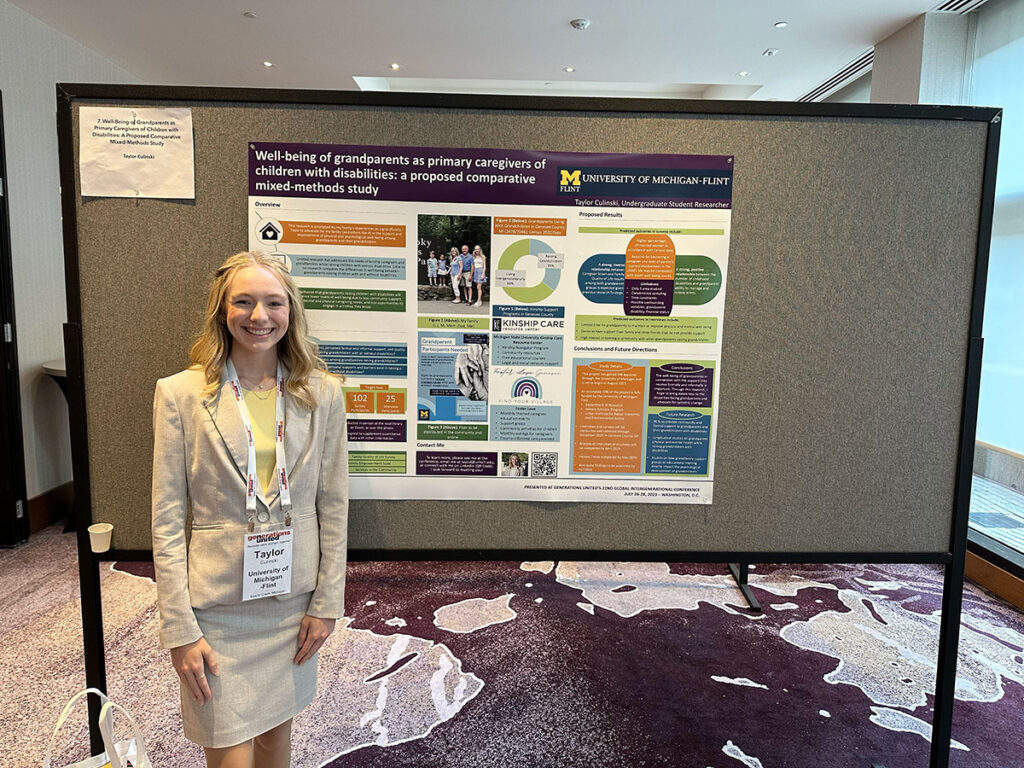 Culinski smiling in front of a research poster. 