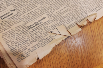 A tattered newspaper on a desk